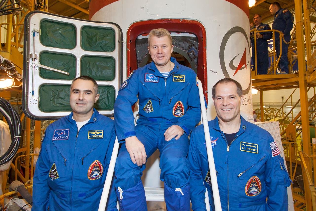 In the Integration Facility at the Baikonur Cosmodrome in Kazakhstan, the Expedition 33/34 prime crew poses for pictures at the hatchway of their Soyuz TMA-06M spacecraft at the completion of their final pre-launch “fit check” dress rehearsal October 18, 2012. Flight Engineer Evgeny Tarelkin (left), Soyuz Commander Oleg Novitskiy (center) and NASA Flight Engineer Kevin Ford (right) will launch October 23 from the Baikonur Cosmodrome for a five-month mission on the International Space Station. NASA/Victor Zelentsov