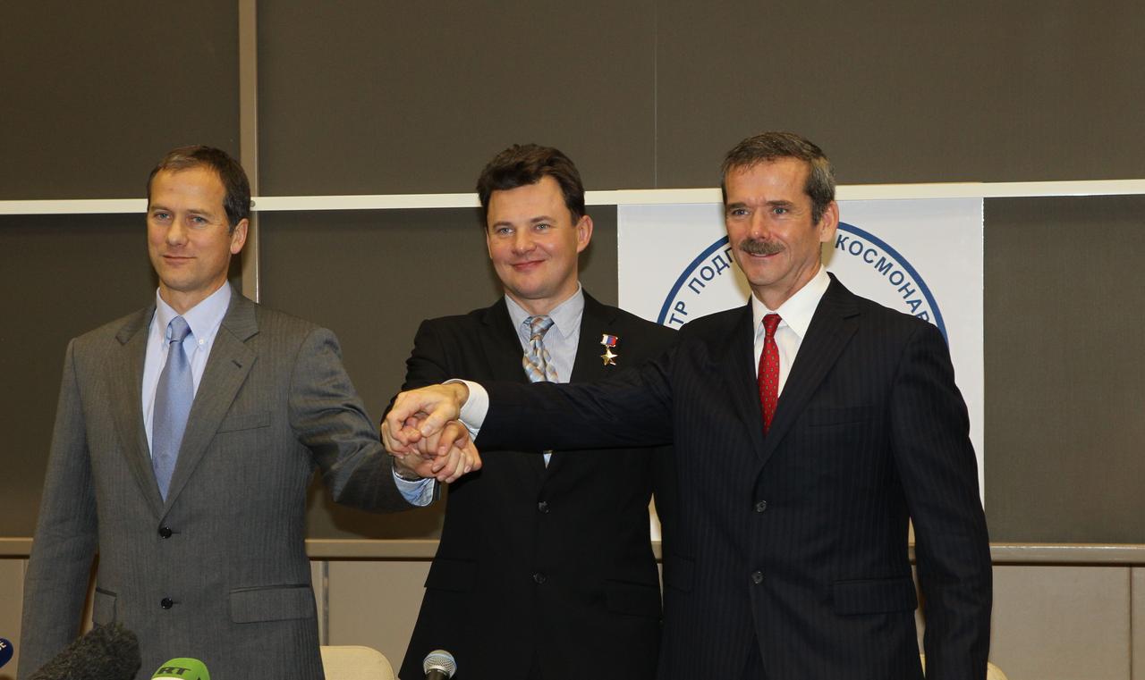 At the Gagarin Cosmonaut Training Center in Star City, Russia, the Expedition 34/35 prime crew clasps hands at the conclusion of a news conference Nov. 29, 2012 as they complete preparations for launch Dec. 19 to the International Space Station in their Soyuz TMA-07M spacecraft from the Baikonur Cosmodrome in Kazakhstan. From left to right are NASA Flight Engineer Tom Marshburn, Soyuz Commander Roman Romanenko and Flight Engineer Chris Hadfield of the Canadian Space Agency. NASA/Stephanie Stoll