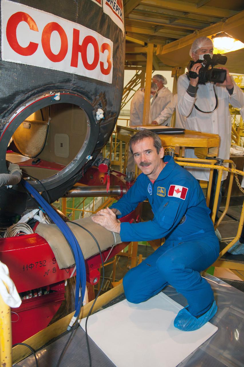 At the Baikonur Cosmodrome in Kazakhstan, Expedition 34/35 Flight Engineer Chris Hadfield of the Canadian Space Agency inspects the Soyuz TMA-07M spacecraft during a “fit check” dress rehearsal Dec. 7, 2012. Hadfield, Soyuz Commander Roman Romanenko and Flight Engineer Tom Marshburn of NASA will launch from Baikonur Dec. 19 for a five-month mission on the International Space Station. Photo Credit: NASA/Victor Zelentsov