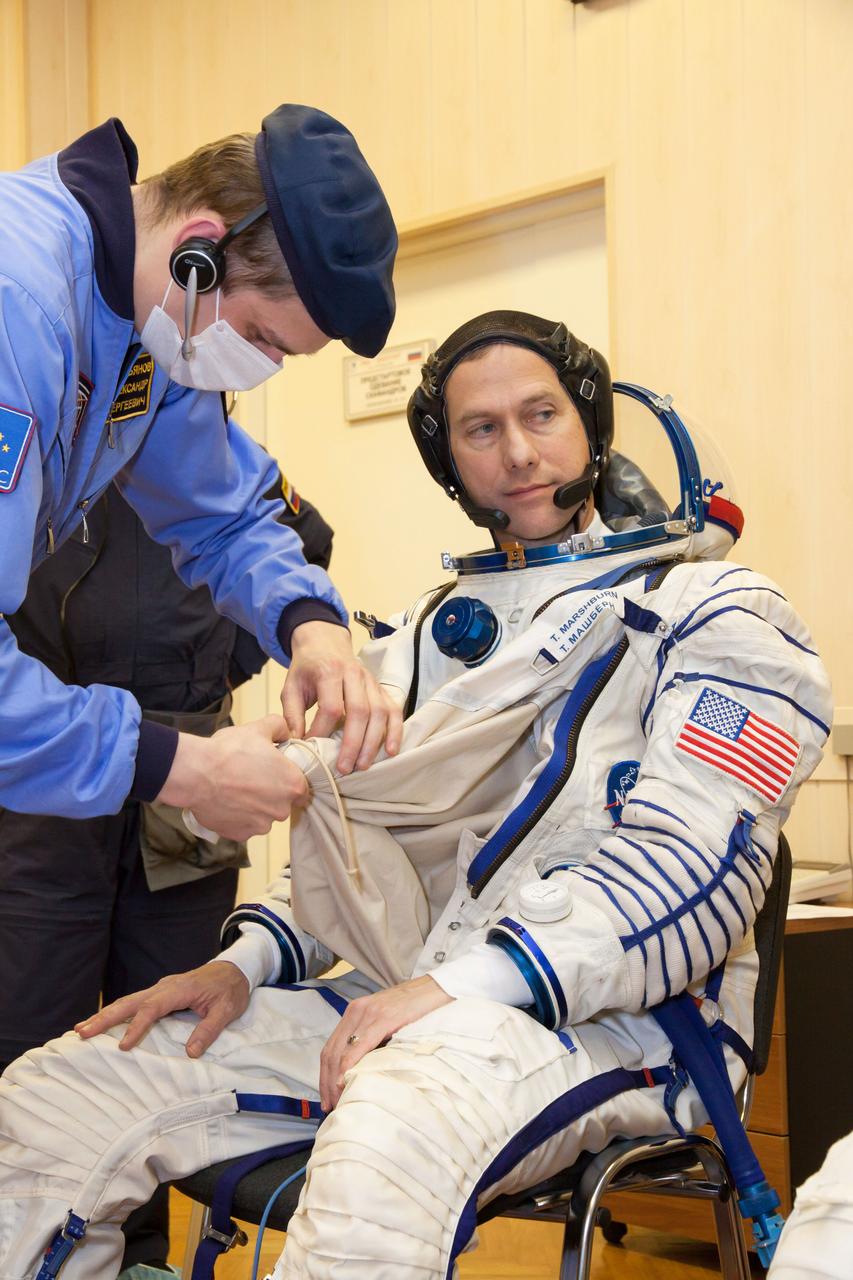 At the Baikonur Cosmodrome in Kazakhstan, Expedition 34/35 Flight Engineer Tom Marshburn of NASA suits up in his Russian Sokol launch and entry suit Dec. 7, 2012 during a “fit check” dress rehearsal for launch in the Soyuz TMA-07M spacecraft. Marshburn, Soyuz Commander Roman Romanenko and Flight Engineer Chris Hadfield of the Canadian Space Agency will launch Dec. 19 for a five-month mission on the International Space Station. Photo Credit: NASA/Victor Zelentsov