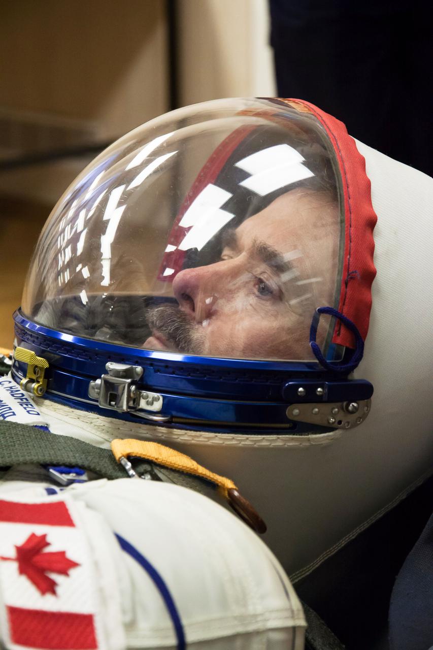 At the Baikonur Cosmodrome in Kazakhstan, Expedition 34/35 Flight Engineer Chris Hadfield of the Canadian Space Agency strikes a serious pose during leak checks of his Russian Sokol launch and entry suit Dec. 7, 2012, part of a “fit check” dress rehearsal for launch in the Soyuz TMA-07M spacecraft. Hadfield, Soyuz Commander Roman Romanenko and Flight Engineer Tom Marshburn will launch Dec. 19 for a five-month mission on the International Space Station. Photo Credit: NASA/Victor Zelentsov