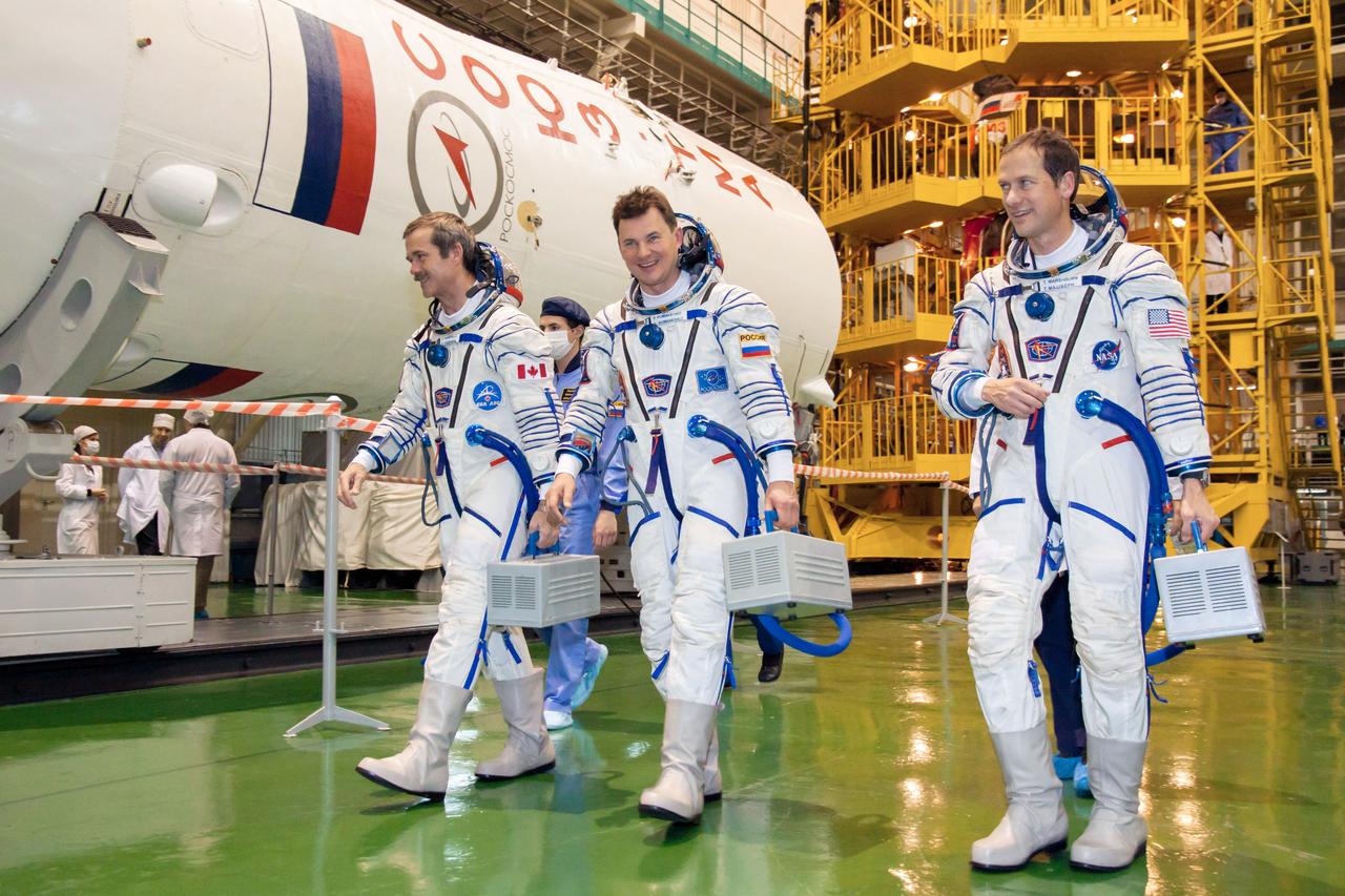 At the Baikonur Cosmodrome’s Integration Facility in Kazakhstan, Expedition 34/35 Flight Engineer Chris Hadfield of the Canadian Space Agency (left), Soyuz Commander Roman Romanenko (center) and Flight Engineer Tom Marshburn (right) depart the test stand housing their Soyuz TMA-07M spacecraft Dec. 7, 2012 following a “fit check” dress rehearsal. The trio is preparing for launch Dec. 19 for a five-month mission on the International Space Station. Photo Credit: NASA/Victor Zelentsov