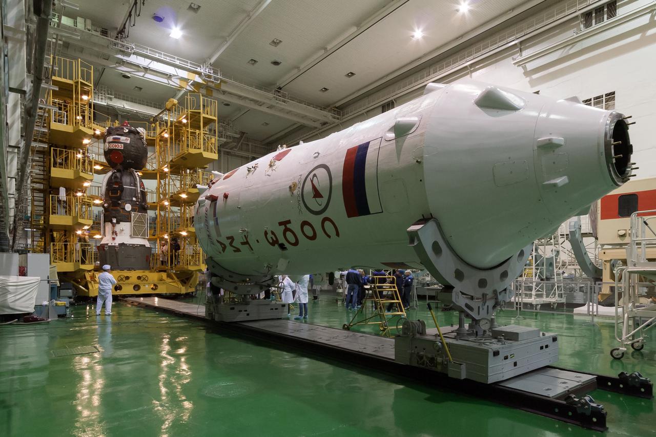 In the Integration Facility at the Baikonur Cosmodrome in Kazakhstan, the Soyuz TMA-07M spacecraft is seen in the background against the Soyuz booster rocket upper stage (in the foreground) as technicians worked to encapsulate the vehicle in the upper stage Dec. 12, 2012 for the launch of the Expedition 34/35 crew. The vehicle will be rolled to the launch pad at Baikonur Dec. 17 in advance of the Dec. 19 launch of NASA Flight Engineer Tom Marshburn, Soyuz Commander Roman Romanenko and Flight Engineer Chris Hadfield of the Canadian Space Agency for a five-month mission on the International Space Station. Photo Credit: NASA/Victor Zelentsov