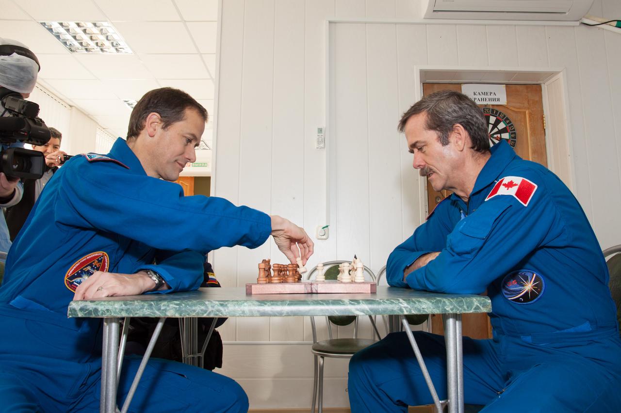 At the Cosmonaut Hotel crew quarters in Baikonur, Kazakhstan, Expedition 34/35 Flight Engineer Tom Marshburn of NASA (left) and Flight Engineer Chris Hadfield of the Canadian Space Agency (right) play a game of chess Dec. 13, 2012 as they prepare for launch Dec. 19 on the Soyuz TMA-07M spacecraft from the Baikonur Cosmodrome with Soyuz Commander Roman Romanenko for five-month mission on the International Space Station. NASA/Victor Zelentsov