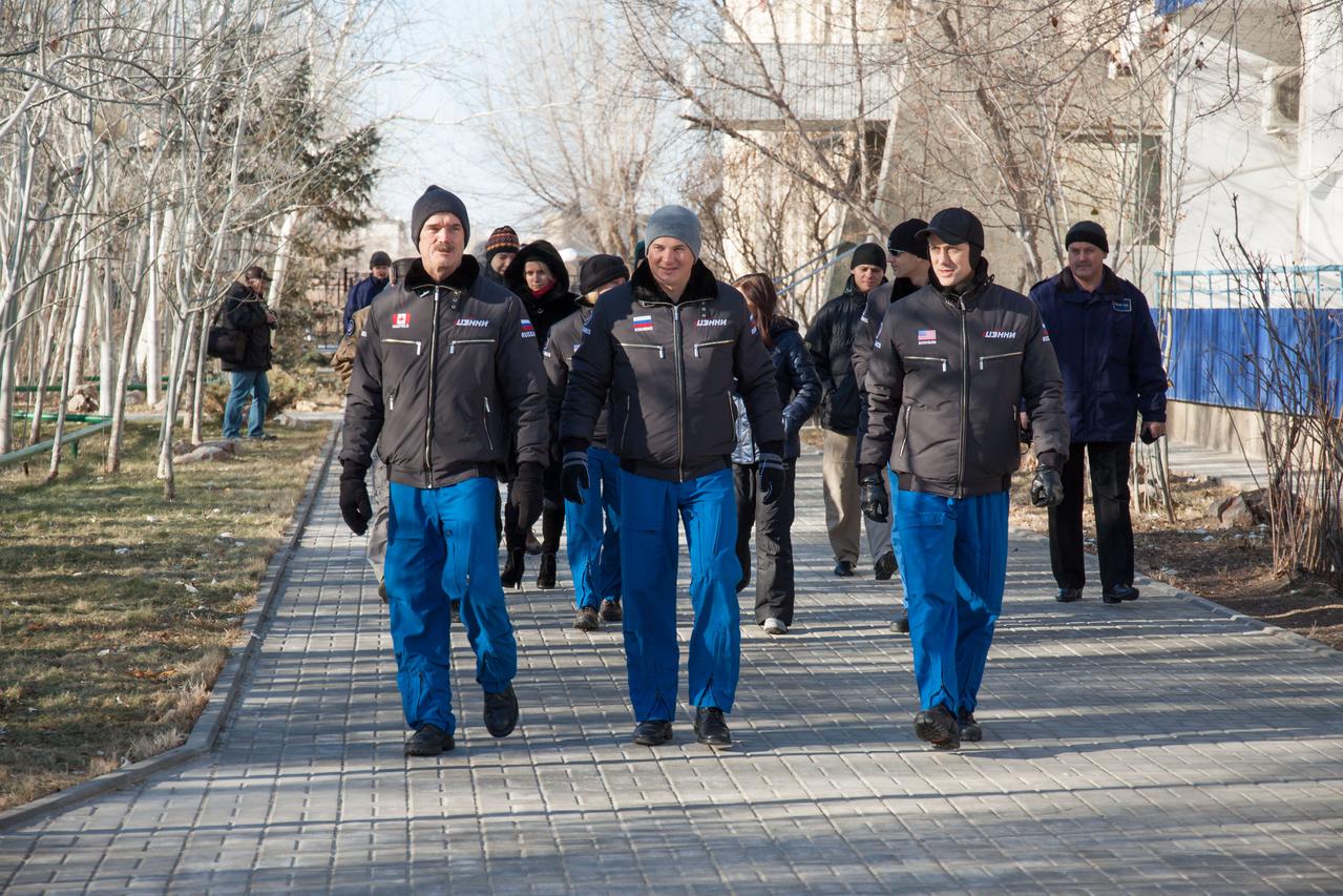 At the Cosmonaut Hotel crew quarters in Baikonur, Kazakhstan, Expedition 34/35 crewmembers Flight Engineer Chris Hadfield of the Canadian Space Agency (left), Soyuz Commander Roman Romanenko (center) and Flight Engineer Tom Marshburn (right) take a stroll down the Walk of Cosmonauts Dec. 13, 2012 as part of traditional pre-launch ceremonies. The trio will launch Dec. 19 from the Baikonur Cosmodrome in Kazakhstan Dec. 19 on the Soyuz TMA-07M spacecraft for a five-month mission on the International Space Station. NASA/Victor Zelentsov