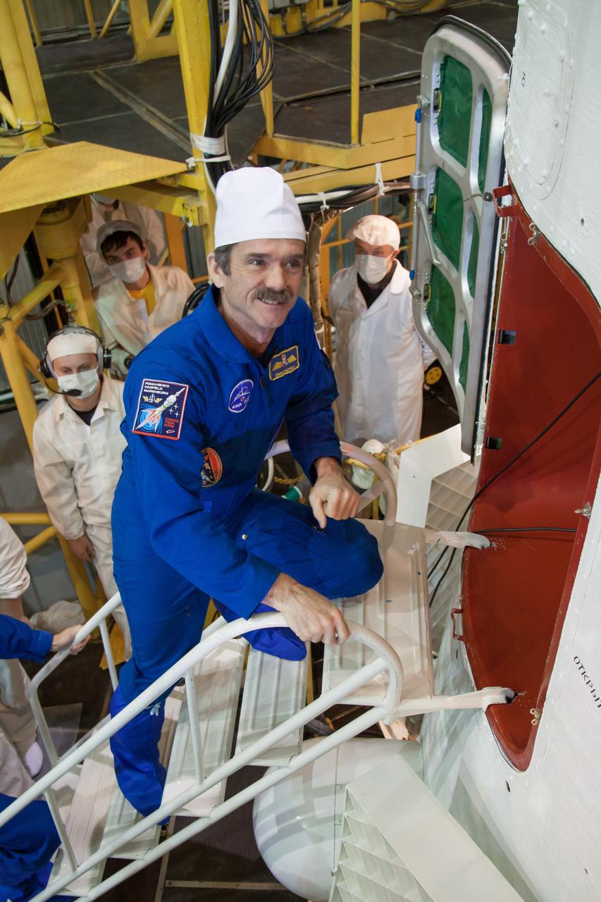 At the Integration Facility at the Baikonur Cosmodrome in Kazakhstan, Expedition 34/35 Flight Engineer Chris Hadfield of the Canadian Space Agency climbs aboard the Soyuz TMA-07M spacecraft for the final “fit check” dress rehearsal Dec. 14, 2012 leading to launch along with Soyuz Commander Roman Romanenko and Flight Engineer Tom Marshburn of NASA Dec. 19 from Baikonur for a five-month mission on the International Space Station. NASA/Victor Zelentsov