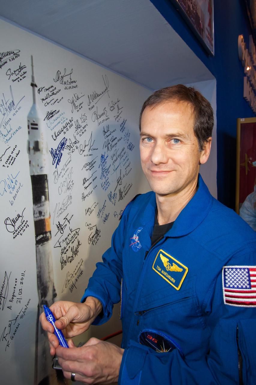 At the Korolev Museum at the Baikonur Cosmodrome in Kazakhstan, Expedition 34/35 Flight Engineer Tom Marshburn of NASA signs a mural of a Soyuz spacecraft launch Dec. 14, 2012, part of a tradition for all space travelers launching from the Central Asian spaceport. Marshburn, Soyuz Commander Roman Romanenko and Flight Engineer Chris Hadfield of the Canadian Space Agency will launch Dec. 19 in the Soyuz TMA-07M spacecraft from Baikonur for a five-month mission on the International Space Station. NASA/Victor Zelentsov