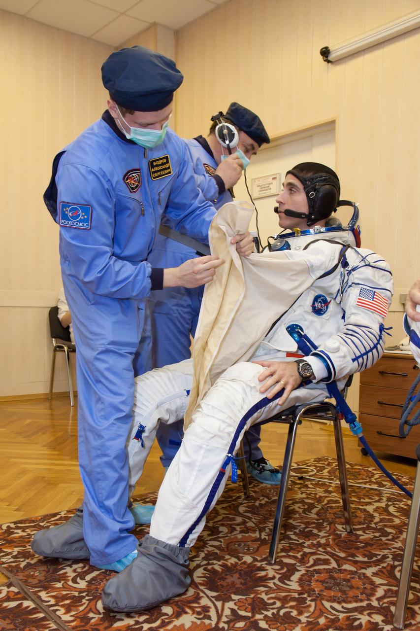 In the Integration Facility at the Baikonur Cosmodrome in Kazakhstan, Russian technicians assist Expedition 35-36 Flight Engineer Chris Cassidy of NASA March 17  as he suits up for a systems dress rehearsal called a “fit check” Cassidy, Soyuz Commander Pavel Vinogradov and Flight Engineer Alexander Misurkin are preparing for launch to the International Space Station from Baikonur on March 29, Kazakh time.  NASA/Victor Zelentsov 
