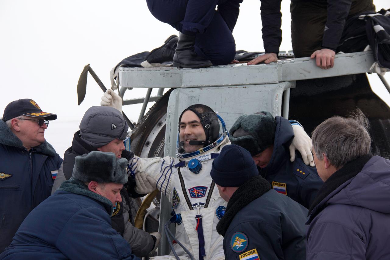 Expedition 34 Flight Engineer Evgeny Tarelkin stands beside his Soyuz TMA-06M spacecraft after being extracted from the vehicle March 16 following  his landing with crewmates Oleg Novitskiy and Kevin Ford of NASA northeast of Arkalyk, Kazakhstan. The three crewmembers returned to Earth after a one-day delay due to inclement weather in the area to wrap up 144 days in space and 142 days aboard the International Space Station.  Courtesy of Sergey Vigovskiy 