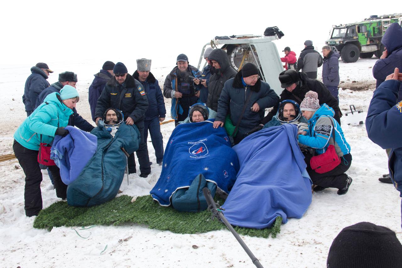 With their Soyuz TMA-06M spacecraft sitting upright behind them, Expedition 34 Flight Engineer Evgeny Tarelkin (left), Soyuz Commander Oleg Novitskiy (center) and Expedition Commander Kevin Ford of NASA (right) rest in reclining chairs following their landing March 16 northeast of Arkalyk, Kazakhstan.  The three crewmembers returned to Earth after a one-day delay due to inclement weather in the area to wrap up 144 days in space and 142 days aboard the International Space Station.  Courtesy of Sergey Vigovskiy 
