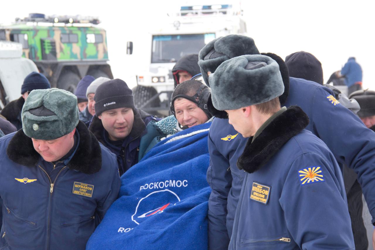 Bundled up against the cold, Expedition 34 Soyuz Commander Oleg Novitskiy is carried to a nearby helicopter March 16 to be flown to Kustanai, Kazakhstan after he, Expedition 34 Commander Kevin Ford of NASA landed in their Soyuz TMA-06M spacecraft northeast of Arkalyk, Kazakhstan. The three crewmembers returned to Earth after a one-day delay due to inclement weather in the area to wrap up 144 days in space and 142 days aboard the International Space Station.  Courtesy of Sergey Vigovskiy 