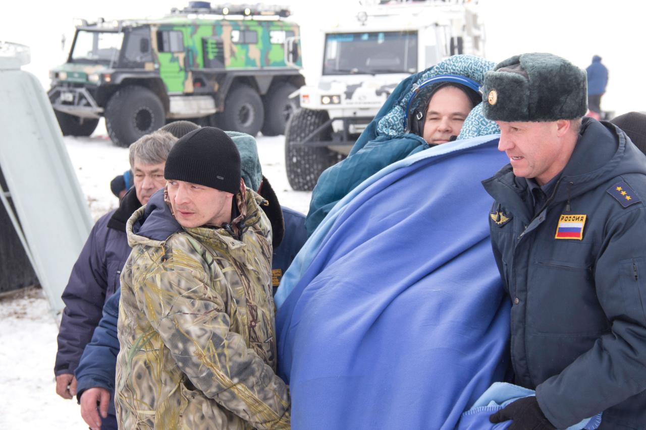 Bundled up against the cold, Expedition 34 Commander Kevin Ford of NASA is carried to a nearby helicopter March 16 to be flown to Kustanai, Kazakhstan after he, Soyuz Commander Oleg Novitskiy and Flight Engineer Evgeny Tarelkin landed in their Soyuz TMA-06M spacecraft northeast of Arkalyk, Kazakhstan. The three crewmembers returned to Earth after a one-day delay due to inclement weather in the area to wrap up 144 days in space and 142 days aboard the International Space Station.  Courtesy of Sergey Vigovskiy 