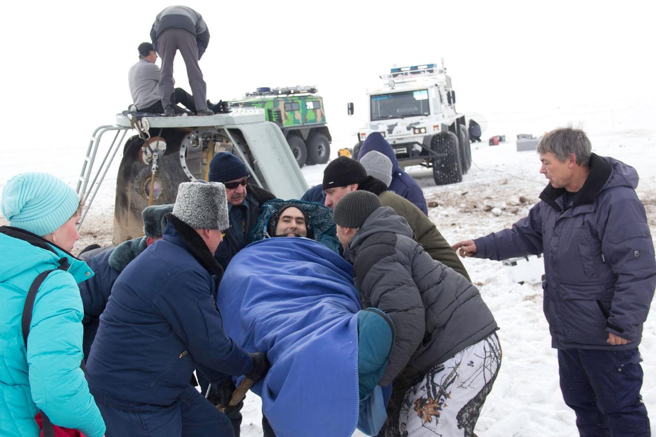 Bundled up against the cold, Expedition 34 Flight Engineer Evgeny Tarelkin is carried to a nearby helicopter March 16 to be flown to Kustanai, Kazakhstan after he, Soyuz Commander Oleg Novitskiy and Expedition 34 Commander Kevin Ford of NASA landed in their Soyuz TMA-06M spacecraft northeast of Arkalyk, Kazakhstan. The three crewmembers returned to Earth after a one-day delay due to inclement weather in the area to wrap up 144 days in space and 142 days aboard the International Space Station.  Courtesy of Sergey Vigovskiy 