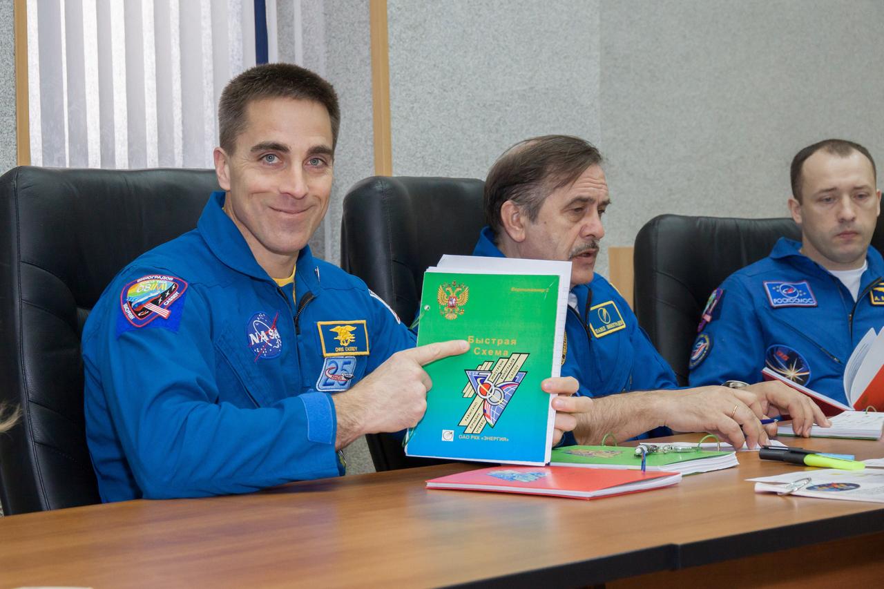 At the Cosmonaut Hotel crew quarters in Baikonur, Kazakhstan, Expedition 35-36 Flight Engineer Chris Cassidy of NASA (left) displays a flight data file book titled “Fast Rendezvous” March 21 as he, Soyuz Commander Pavel Vinogradov (center) and Flight Engineer Alexander Misurkin (right) train for launch to the International Space Station March 29, Kazakh time, in their Soyuz TMA-08M spacecraft from the Baikonur Cosmodrome for a 5 ½ month mission. The “fast rendezvous” refers to the expedited four-orbit, six-hour trip from the launch pad to reach the International Space Station March 29 through an accelerated rendezvous burn plan, the first time this approach will be used for crews flying to the international complex. NASA/Victor Zelentsov