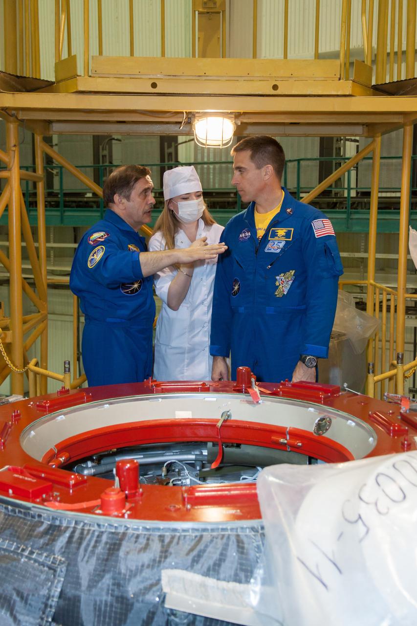 At the Integration Facility at the Baikonur Cosmodrome in Kazakhstan, Expedition 35/36 Soyuz Commander Pavel Vinogradov (left) and Flight Engineer Chris Cassidy of NASA (right) discuss the ISS Progress 51 cargo ship in front of them March 23 that is being prepared for launch to the International Space Station in late April and which will be greeted by the trio and three other crewmates. Cassidy, Vinogradov and Flight Engineer Alexander Misurkin are in the final days of training for their launch March 29, Kazakh time, to the International Space Station from the Baikonur Cosmodrome in their Soyuz TMA-08M spacecraft for a 5 ½ month mission. NASA/Victor Zelentsov