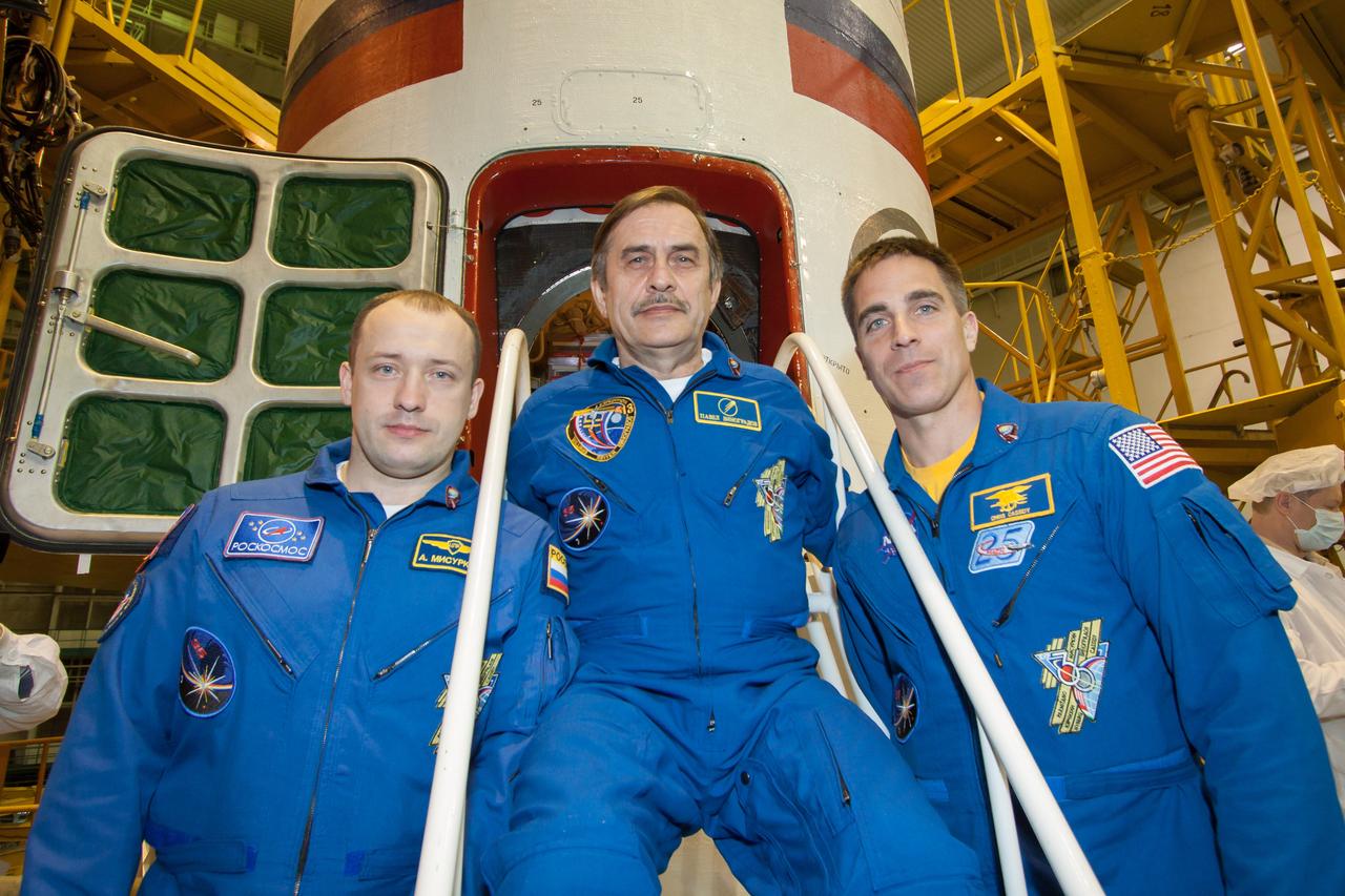 At the Integration Facility at the Baikonur Cosmodrome in Kazakhstan, Expedition 35/36 Flight Engineer Alexander Misurkin (left), Soyuz Commander Pavel Vinogradov (center) and Flight Engineer Chris Cassidy of NASA (right) pose for pictures March 23 in front of the Soyuz TMA-08M spacecraft in which they will launch to the International Space Station March 29, Kazakh time, from the Baikonur Cosmodrome. The three crewmembers will spend 5 ½ months on the orbital laboratory.  NASA/Victor Zelentsov 