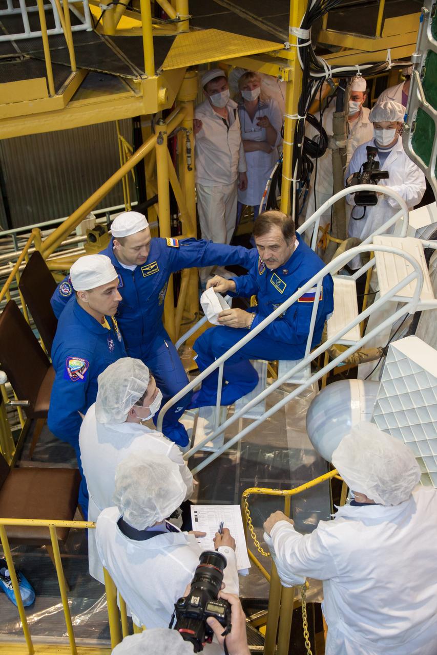 Surrounded by technicians at the Integration Facility at the Baikonur Cosmodrome in Kazakhstan, Expedition 35/36 Flight Engineer Chris Cassidy of NASA (left), Flight Engineer Alexander Misurkin (center) and Soyuz Commander Pavel Vinogradov (right) discuss the preparation of their Soyuz TMA-08M spacecraft March 23 during a final inspection of the vehicle. The three crewmembers will launch in the Soyuz TMA-08M spacecraft to the International Space Station on March 29, Kazakh time, from the Baikonur Cosmodrome for a 5 ½ month mission on the orbital laboratory.  NASA/Victor Zelentsov 