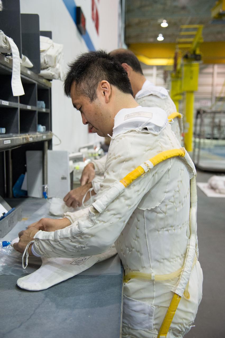 PHOTO DATE:  03-28-13 LOCATION:  NBL - Pool Topside  SUBJECT:  Expedition 39 (Soyuz 37) crew members Rick Mastracchio and Koichi Wakata during pre-dive briefing, preparations and suitup, then lowering into the water. PHOTOGRAPHER: BILL STAFFORD