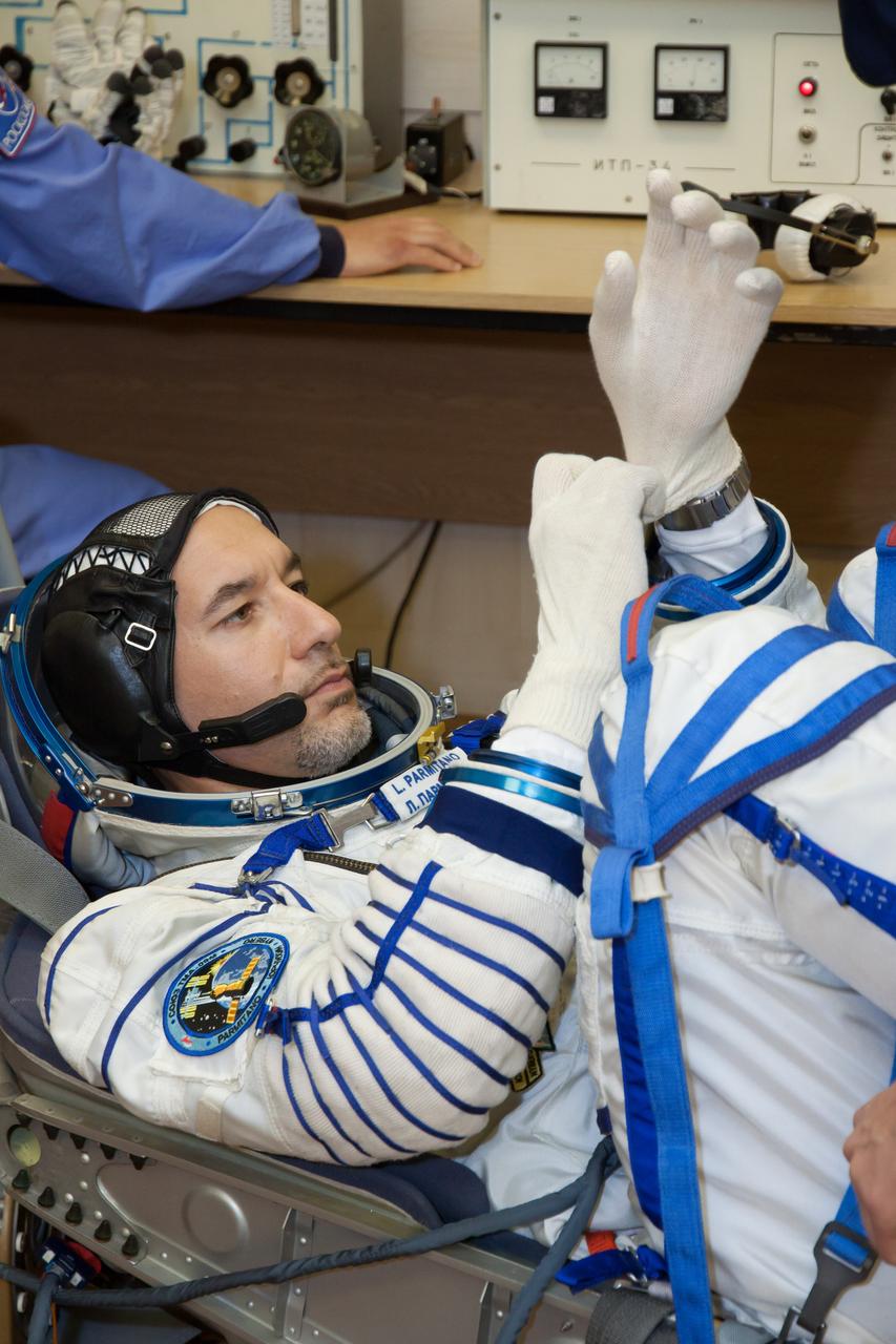 In the Integration Facility at the Baikonur Cosmodrome in Kazakhstan, Expedition 36/37 Flight Engineer Luca Parmitano of the European Space Agency checks his gloves during a portion of a suited dress rehearsal “fit check” exercise May 17. Parmitano, NASA Flight Engineer Karen Nyberg and Soyuz Commander Fyodor Yurchikhin will launch May 29, Kazakh time, in their Soyuz TMA-09M spacecraft to begin a 5 ½ mission on the International Space Station.  NASA/Victor Zelentsov 