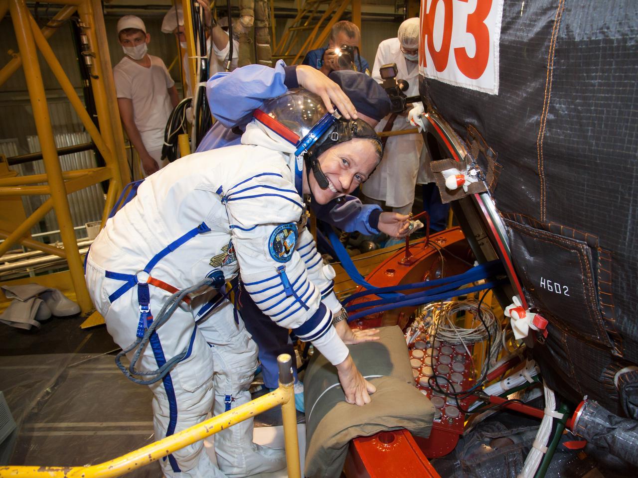 In the Integration Facility at the Baikonur Cosmodrome in Kazakhstan, Expedition 36/37 Flight Engineer Karen Nyberg of NASA climbs aboard the Soyuz TMA-09M spacecraft May 17 during a suited dress rehearsal “fit check” exercise. Nyberg, Flight Engineer Luca Parmitano of the European Space Agency and Soyuz Commander Fyodor Yurchikhin will launch May 29, Kazakh time, in their Soyuz vehicle to begin a 5 ½ mission on the International Space Station.  NASA/Victor Zelentsov 