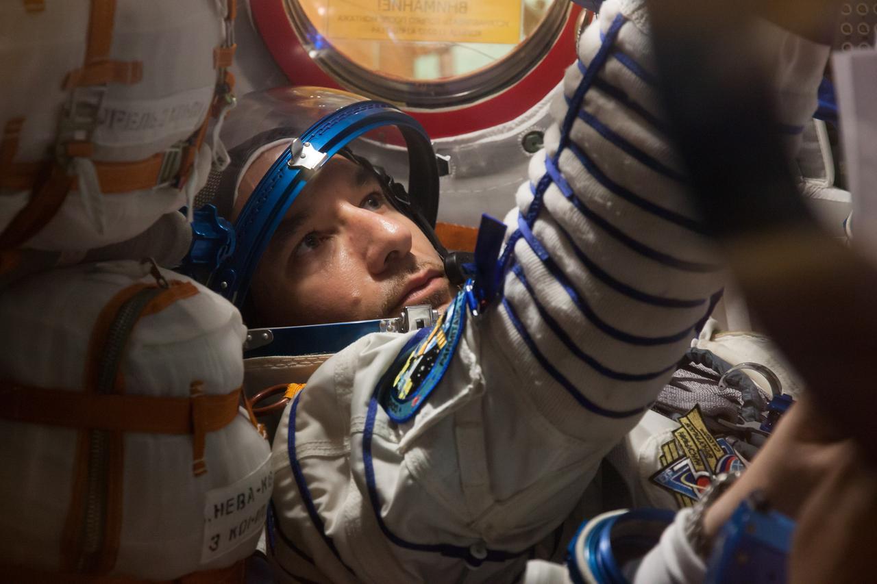 In the Integration Facility at the Baikonur Cosmodrome in Kazakhstan, Expedition 36/37 Flight Engineer Luca Parmitano of the European Space Agency is seen inside the Soyuz TMA-09M spacecraft May 17 as he, NASA Flight Engineer Karen Nyberg and Soyuz Commander Fyodor Yurchikhin conducted a suited “fit check” dress rehearsal exercise. The trio will launch May 29, Kazakh time, in their Soyuz vehicle to begin a 5 ½ mission on the International Space Station.  NASA/Victor Zelentsov 