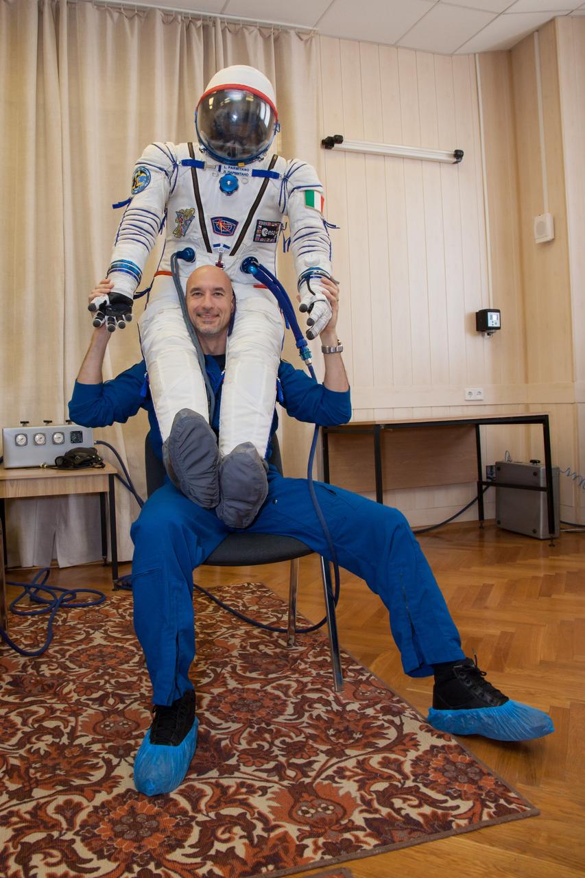 In the Integration Facility at the Baikonur Cosmodrome in Kazakhstan, Expedition 36/37 Flight Engineer Luca Parmitano of the European Space Agency poses with his Russian Sokol launch and entry suit May 17 during a suited dress rehersal “fit check” exercise. Parmitano, Flight Engineer Karen Nybergof NASA and Soyuz Commander Fyodor Yurchikhin will launch May 29, Kazakh time, in their Soyuz TMA-09M spacecraft to begin a 5 ½ mission on the International Space Station.  NASA/Victor Zelentsov 