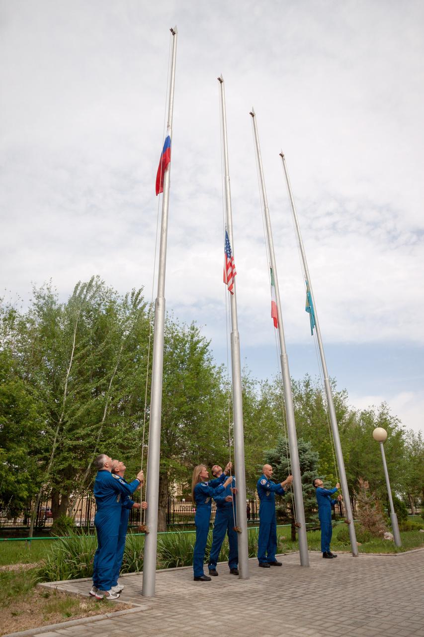 Outside their Cosmonaut Hotel crew quarters in Baikonur, Kazakhstan, the Expedition 36/37 prime and backup crewmembers conducted the traditional raising of flags of their countries and host country Kazakhstan May 18 as they prepare for the launch of NASA Flight Engineer Karen Nyberg, Soyuz Commander Fyodor Yurchikhin and Flight Engineer Luca Parmitano of the European Space Agency May 29, Kazakh time, in the Soyuz TMA-09M spacecraft to begin a 5 ½ month mission on the International Space Station. Hoisting the flags of Russia, the U.S., Italy and Kazakhstan from left to right are Yurchikhin, backup Soyuz Commander Mikhail Tyurin, Nyberg, backup NASA Flight Engineer Rick Mastracchio, Parmitano and backup Flight Engineer Koichi Wakata of the Japan Aerospace Exploration Agency. NASA/Victor Zelentsov