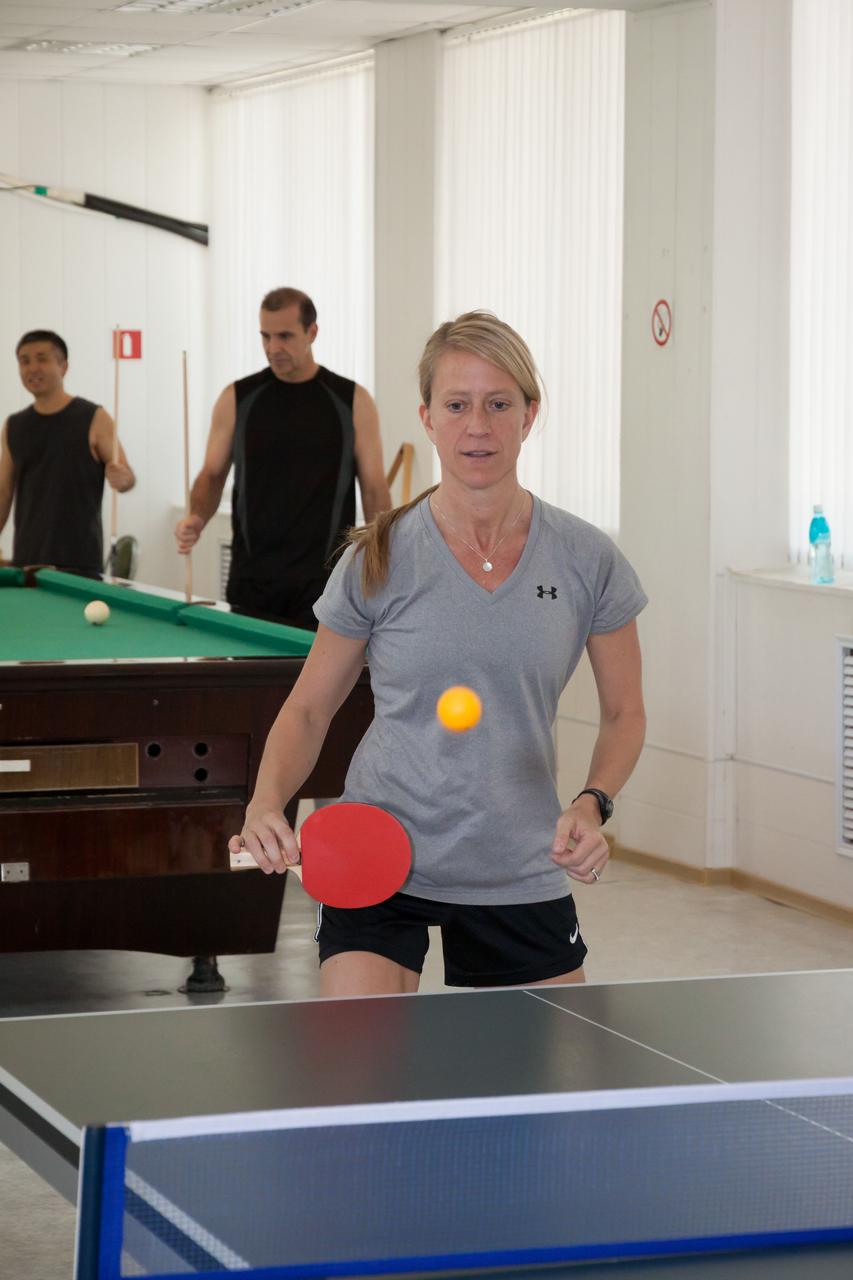 In the Cosmonaut Hotel crew quarters in Baikonur, Kazakhstan, Expedition 36/37 Flight Engineer Karen Nyberg of NASA gets in a round of Ping-Pong May 22 as she limbers up for launch May 29, Kazakh time, in the Soyuz TMA-09M spacecraft with Soyuz Commander Fyodor Yurchikhin and Flight Engineer Luca Parmitano of the European Space Agency to begin a 5 ½ month mission on the International Space Station. In the background at the billiards table are backup crewmembers Koichi Wakata of the Japan Aerospace Exploration Agency (left) and Rick Mastracchio of NASA (right).  NASA/Victor Zelentsov 