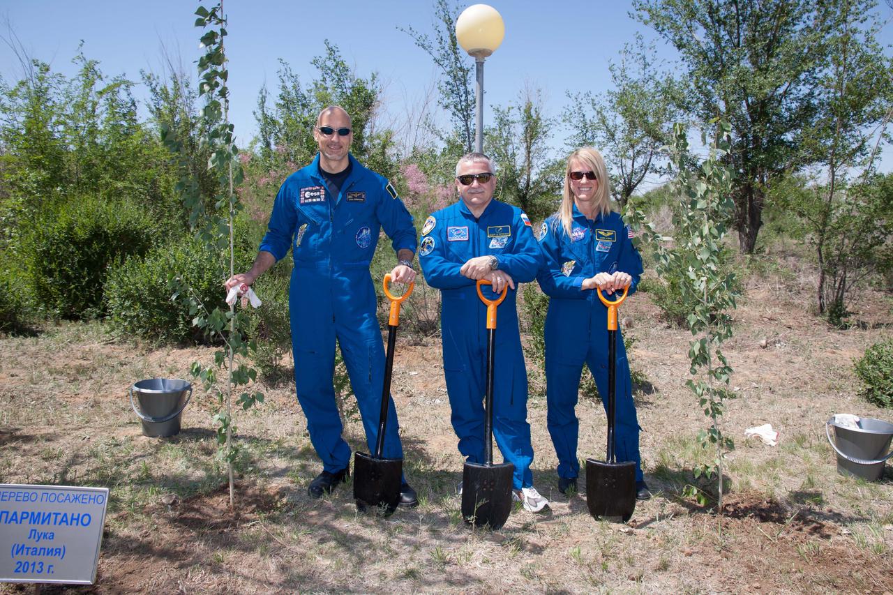 Behind the Cosmonaut Hotel crew quarters in Baikonur, Kazakhstan, Expedition 36/37 Flight Engineer Luca Parmitano of the European Space Agency (left), Soyuz Commander Fyodor Yurchikhin (center) and Flight Karen Nyberg of NASA (right) pose for pictures May 22 following a traditional tree-planting ceremony. Nyberg, Yurchikhin and Parmitano are preparing for their launch May 29, Kazakh time, in the Soyuz TMA-09M spacecraft to begin a 5 ½ month mission on the International Space Station.  NASA/Victor Zelentsov 