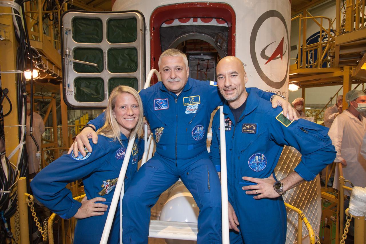 At the Baikonur Cosmodrome in Kazakhstan, Expedition 36/37 Flight Engineer Karen Nyberg of NASA (left), Soyuz Commander Fyodor Yurchikhin (center) and Flight Engineer Luca Parmitano of the European Space Agency (right) pose for pictures in front of their Soyuz TMA-09M spacecraft May 24 as they complete the second “fit check” dress rehearsal in advance of their launch. Nyberg , Yurchikhin and Parmitano are preparing for launch May 29, Kazakh time, in the Soyuz to begin a 5 ½ month mission on the International Space Station.  NASA/Victor Zelentsov 