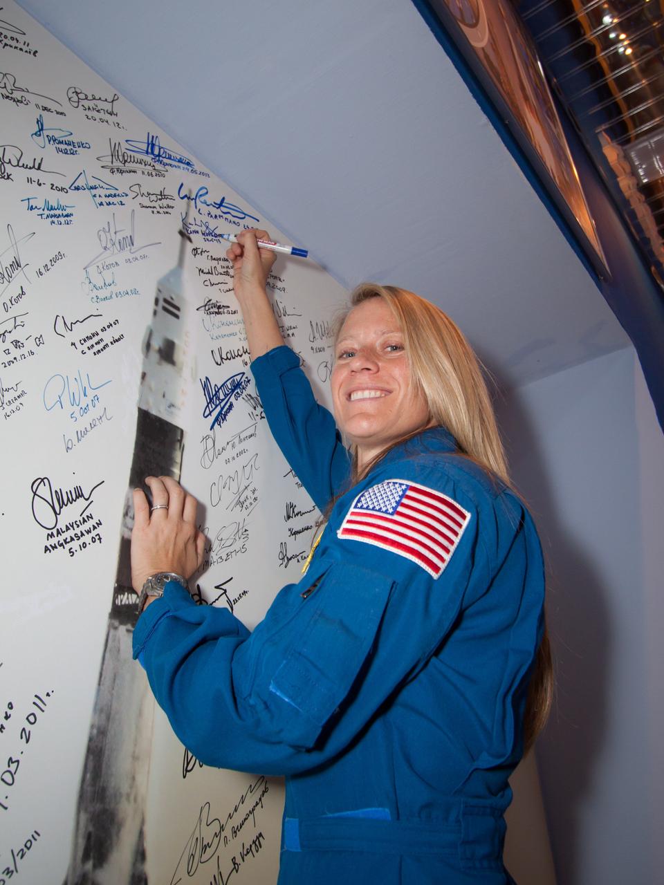 At the Baikonur Cosmodrome in Kazakhstan, Expedition 36/37 Flight Engineer Karen Nyberg of NASA signs a mural depicting a Soyuz rocket launch in the Korolev Museum May 24 following the final “fit check” dress rehearsal before launch. Nyberg, Flight Engineer Luca Parmitano of the European Space Agency and Soyuz Commander Fyodor Yurchikhin are preparing for launch May 29, Kazakh time, in the Soyuz TMA-09M spacecraft to begin a 5 ½ month mission on the International Space Station.  NASA/Victor Zelentsov 