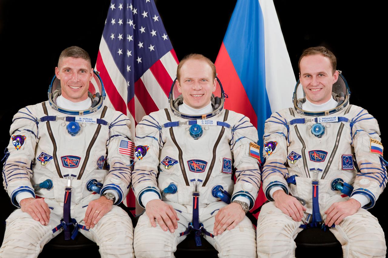 JSC2013-E-075999 (18 June 2013) --- Russian cosmonaut Oleg Kotov (center), Expedition 37 flight engineer and Expedition 38 commander; along with NASA astronaut Michael Hopkins (left) and Russian cosmonaut Sergey Ryazanskiy, both Expedition 37/38 flight engineers, attired in Russian Sokol launch and entry suits, take a break from training in Star City, Russia to pose for a crew portrait. Photo credit: Gagarin Cosmonaut Training Center
