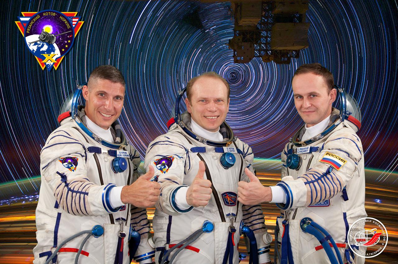 JSC2013-E-076004 (20 June 2013) --- Russian cosmonaut Oleg Kotov (center), Expedition 37 flight engineer and Expedition 38 commander; along with NASA astronaut Michael Hopkins (left) and Russian cosmonaut Sergey Ryazanskiy, both Expedition 37/38 flight engineers, attired in Russian Sokol launch and entry suits, take a break from training in Star City, Russia to pose for a crew portrait. Photo credit: Gagarin Cosmonaut Training Center