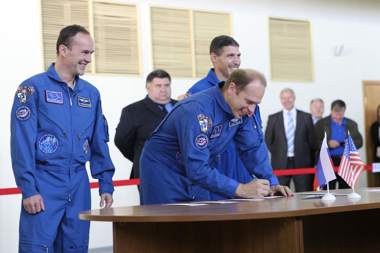 At the Gagarin Cosmonaut Training Center in Star City, Russia, Expedition 37/38 Soyuz Commander Oleg Kotov (center) signs in Sept. 3 prior to the start of a round of qualification exams for his launch to the International Space Station later this month. Looking on are his crewmates, Flight Engineer Sergey Ryazanskiy (left) and NASA Flight Engineer Michael Hopkins (right). The trio is in the final weeks of training for launch Sept. 26 from the Baikonur Cosmodrome in Kazakhstan in the Soyuz TMA-10M spacecraft. NASA/Stephanie Stoll