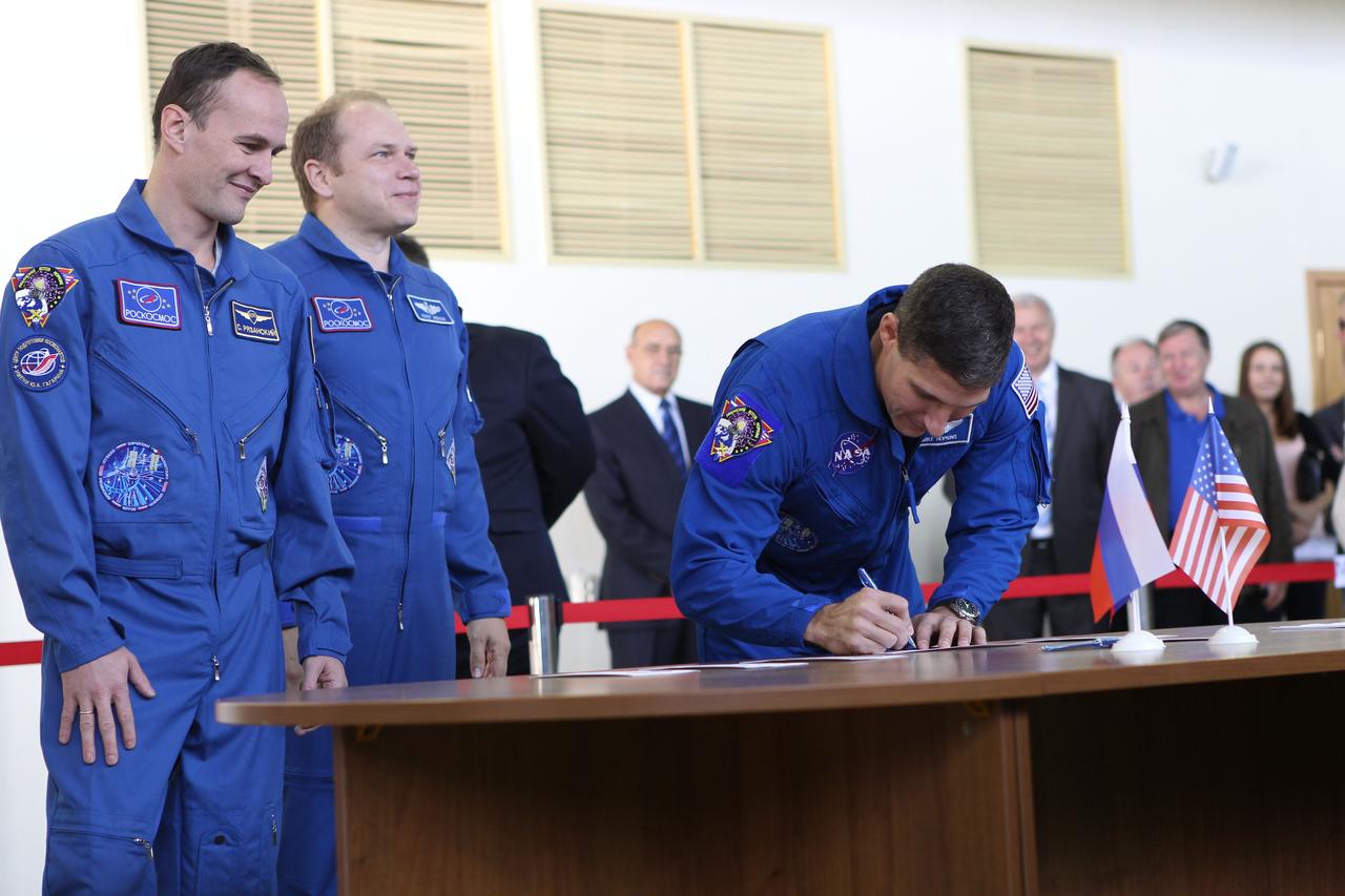 At the Gagarin Cosmonaut Training Center in Star City, Russia, Expedition 37/38 Flight Engineer Michael Hopkins of NASA (right) signs in Sept. 3 prior to the start of a round of qualification exams for his launch to the International Space Station later this month. Looking on are his crewmates, Flight Engineer Sergey Ryazanskiy (left) and Soyuz Commander Oleg Kotov (center). The trio is in the final weeks of training for launch Sept. 26 from the Baikonur Cosmodrome in Kazakhstan in the Soyuz TMA-10M spacecraft. NASA/Stephanie Stoll