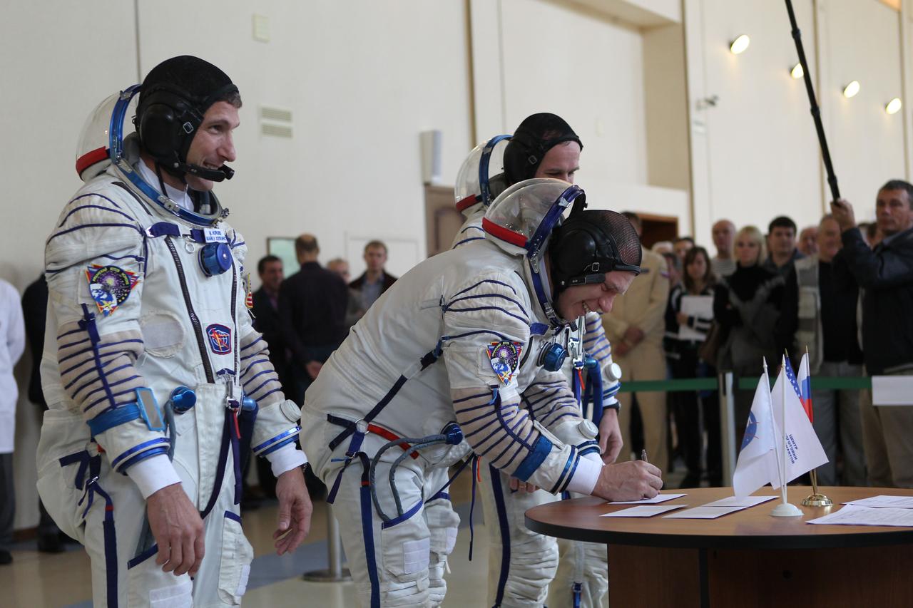 At the Gagarin Cosmonaut Training Center in Star City, Russia, Expedition 37/38 Soyuz Commander Oleg Kotov signs in for a round of qualification exams Sept. 4 as his crewmates, NASA Flight Engineer Michael Hopkins (left) and Sergey Ryazanskiy (partially hidden behind Kotov) look on. The trio is in final training for launch on Sept. 26, Kazakh time, from the Baikonur Cosmodrome in Kazakhstan on the Soyuz TMA-10M spacecraft for a 5 ½ month mission on the International Space Station. NASA/Stephanie Stoll