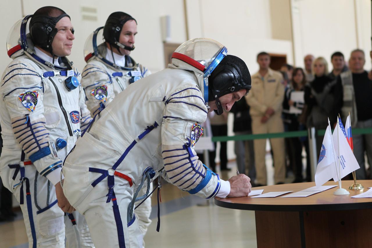 At the Gagarin Cosmonaut Training Center in Star City, Russia, Expedition 37/38 Flight Engineer Michael Hopkins of NASA signs in for a round of qualification exams Sept. 4 as his crewmates, Soyuz Commander Oleg Kotov (left) and Sergey Ryazanskiy (right) look on. The trio is in final training for launch on Sept. 26, Kazakh time, from the Baikonur Cosmodrome in Kazakhstan on the Soyuz TMA-10M spacecraft for a 5 ½ month mission on the International Space Station. NASA/Stephanie Stoll