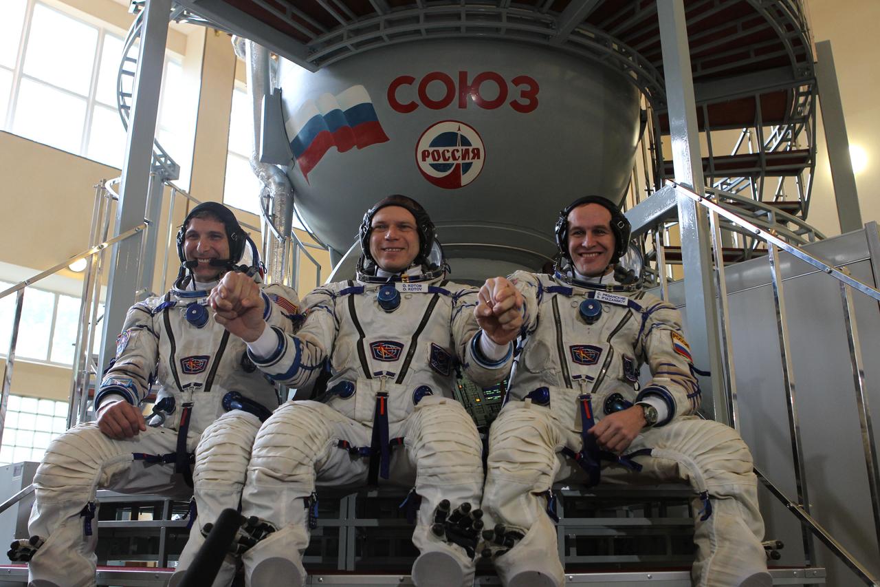 At the Gagarin Cosmonaut Training Center in Star City, Russia, Expedition 37/38 Soyuz Commander Oleg Kotov (center), Flight Engineer Michael Hopkins of NASA (left) and Flight Engineer Sergey Ryazanskiy (right) clasp hands during a qualification exam Sept. 4. The trio is in final training for launch on Sept. 26, Kazakh time, from the Baikonur Cosmodrome in Kazakhstan on the Soyuz TMA-10M spacecraft for a 5 ½ month mission on the International Space Station. NASA/Stephanie Stoll