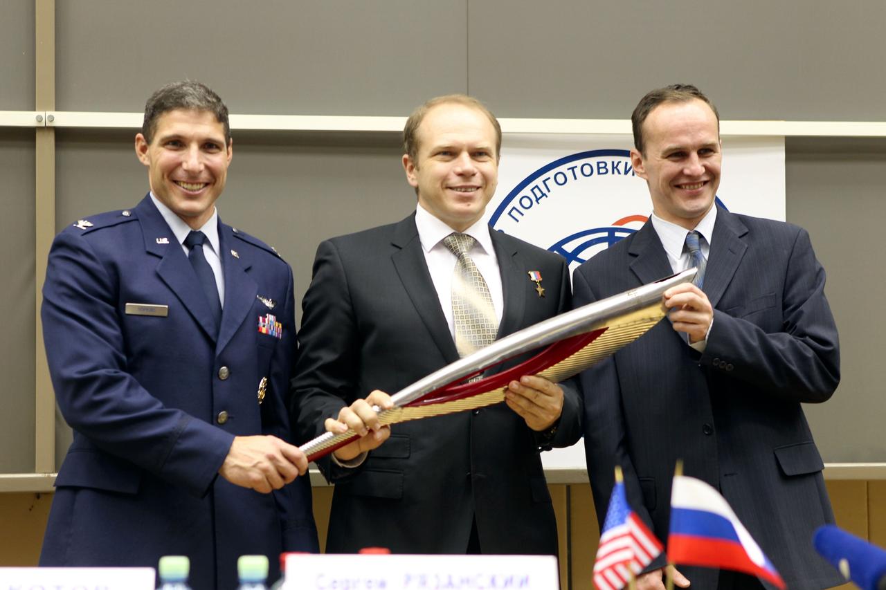 At the Gagarin Cosmonaut Training Center in Star City, Russia, Expedition 37/38 Flight Engineer Michael Hopkins of NASA (left), Soyuz Commander Oleg Kotov (center) and Flight Engineer Sergey Ryazanskiy (right) hold a replica of the Olympic torch Sept. 6 following a crew news conference at their training facility outside Moscow. The trio is preparing for their launch to the International Space Station from the Baikonur Cosmodrome in Kazakhstan on Sept. 26, Kazakh time, aboard the Soyuz TMA-10M spacecraft. The torch that will light the Olympic flame at the Opening Ceremonies of the Winter Olympics in Sochi, Russia Feb. 7, 2014 will be flown the space station by another crew in November and brought home several days later as part of a global and galactic Olympic relay.  NASA/Stephanie Stoll