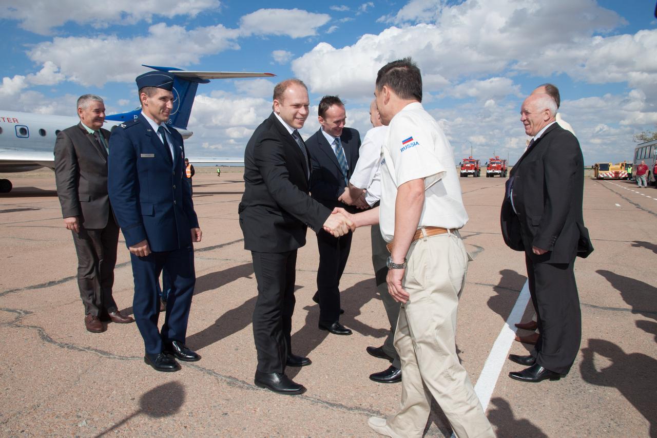 Flanked by his crewmates, Expedition 37/38 Flight Engineer Michael Hopkins of NASA (left) and Flight Engineer Sergey Ryazanskiy (right), Soyuz Commander Oleg Kotov (center) is greeted by Russian space officials at an airport in Baikonur, Kazakhstan Sept. 13 near the launch site at the Baikonur Cosmodrome after a flight from their training base outside Moscow earlier in the day. Hopkins, Kotov and Ryazanskiy will launch from Baikonur Sept. 26, Kazakh time, in the Soyuz TMA-10M spacecraft for a five and a half month mission on the International Space Station. NASA/Victor Zelentsov