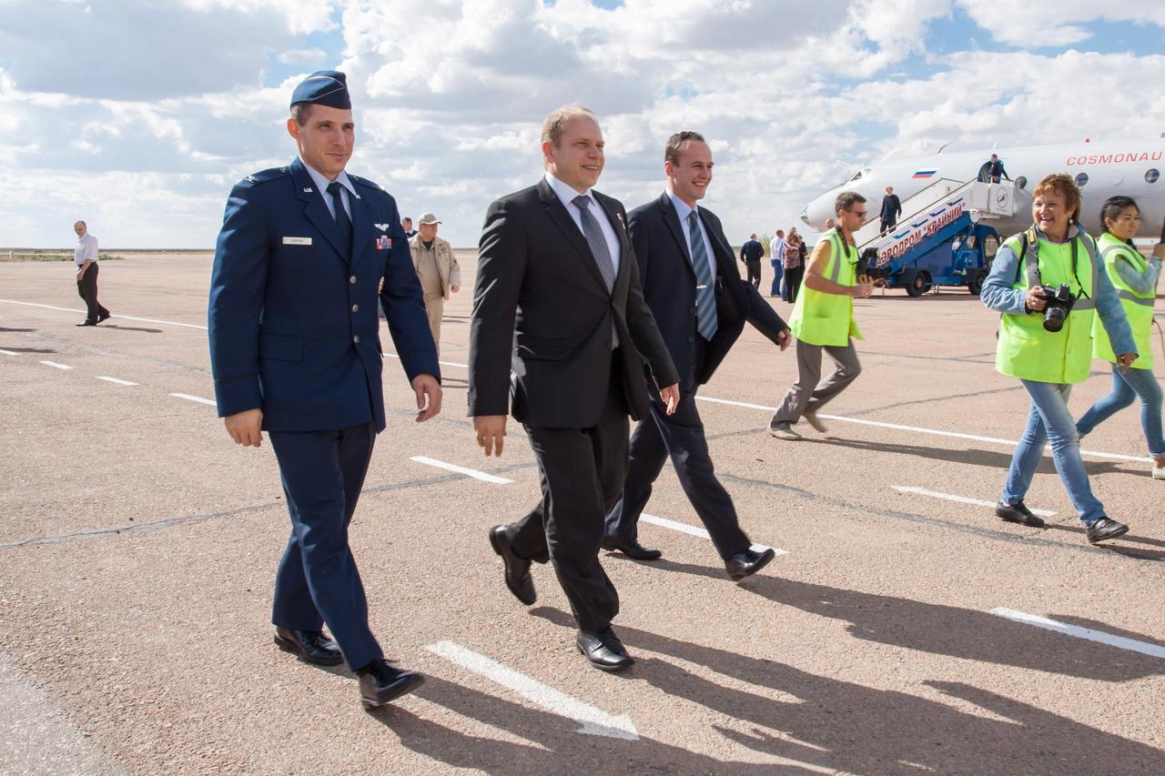 Expedition 37/38 Flight Engineer Michael Hopkins of NASA (left), Soyuz Commander Oleg Kotov (center) and Flight Engineer Sergey Ryazanskiy (right) walk to ground transportation at an airport in Baikonur, Kazakhstan near the launch site at the Baikonur Cosmodrome Sept. 13 following a flight from their training base outside of Moscow.  Hopkins, Kotov and Ryazanskiy will launch from Baikonur Sept. 26, Kazakh time, in the Soyuz TMA-10M spacecraft for a five and a half month mission on the International Space Station.  NASA/Victor Zelentsov 