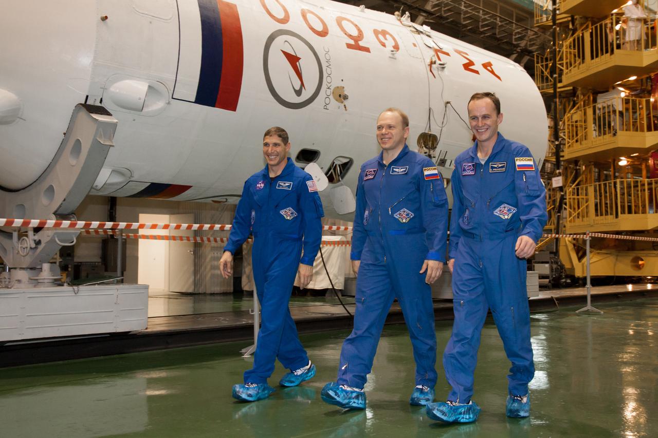 At the Baikonur Cosmodrome in Kazakhstan, Expedition 37/38 Flight Engineer Michael Hopkins of NASA (left), Soyuz Commander Oleg Kotov (center) and Flight Engineer Sergey Ryazanskiy (right) walk past the Soyuz booster rocket Sept. 14 during a “fit check” dress rehearsal training exercise. The three crewmembers are preparing for launch Sept. 26, Kazakh time, from Baikonur on their Soyuz TMA-10M spacecraft to begin a five and a half month mission on the International Space Station.  NASA/Victor Zelentsov 
