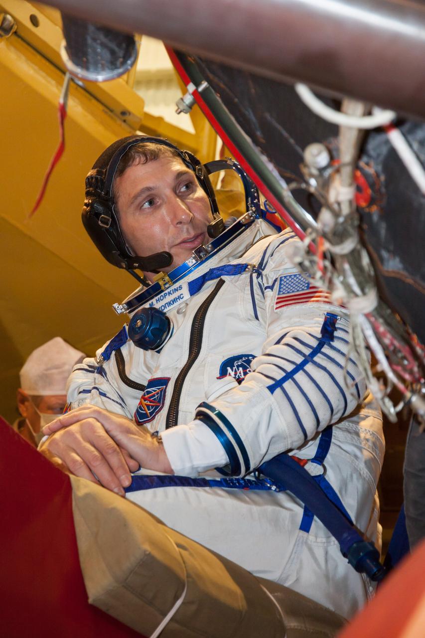 At the Baikonur Cosmodrome in Kazakhstan, Expedition 37/38 Flight Engineer Michael Hopkins of NASA focuses on a piece of hardware Sept. 14 as part of a “fit check” dress rehearsal training exercise. Hopkins, Soyuz Commander Oleg Kotov and Flight Sergey Ryazanskiy are preparing for launch Sept. 26, Kazakh time, from Baikonur on their Soyuz TMA-10M spacecraft to begin a five and a half month mission on the International Space Station.  NASA/Victor Zelentsov 