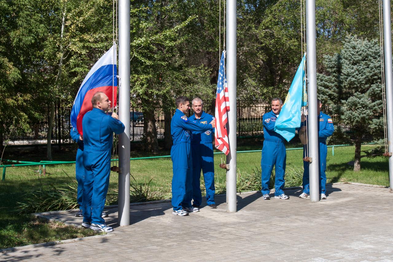 At their Cosmonaut Hotel crew quarters in Baikonur, Kazakhstan, the Expedition 37/38 prime and backup crewmembers prepare to raise the U.S., Russian and Kazakh flags Sept. 15 in a traditional ceremony. From left to right are prime Soyuz Commander Oleg Kotov, prime Flight Engineer Michael Hopkins of NASA, his backup, Steve Swanson of NASA and backup Alexander Skvortsov (far right). Hidden from view are prime Flight Engineer Sergei Ryazanskiy and his backup, Oleg Artemyev. Hopkins, Kotov and Ryazanskiy are preparing for launch Sept. 26, Kazakh time, from Baikonur on their Soyuz TMA-10M spacecraft to begin a five and a half month mission on the International Space Station. NASA/Victor Zelentsov
