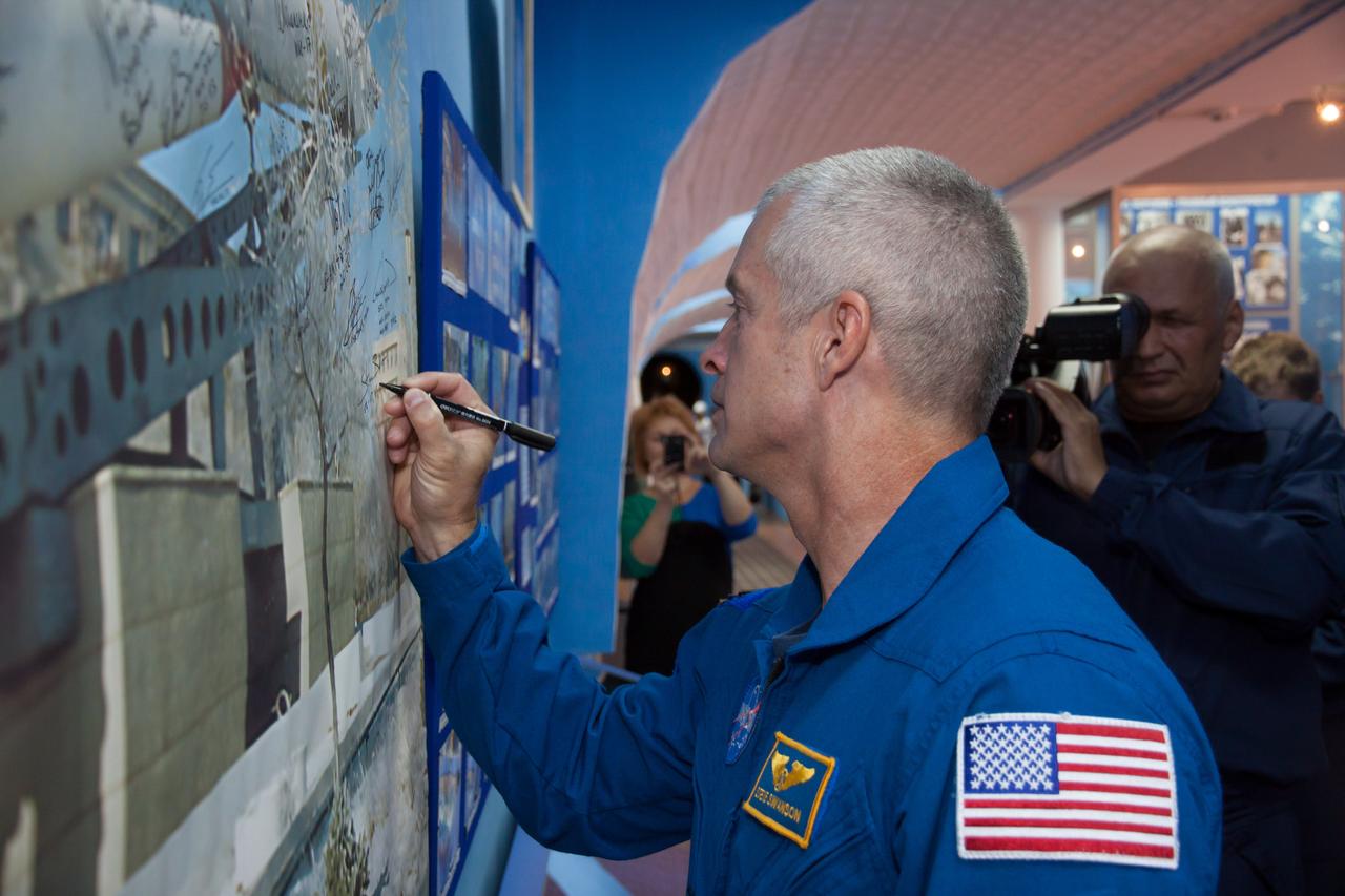Expedition 37/38 backup crewmember Steve Swanson of NASA signs a wall mural depicting a Soyuz rocket during a tour of the famed Korolev Museum at the Baikonur Cosmodrome in Kazakhstan Sept. 17. Swanson, Alexander Skvortsov and Oleg Artemyev are serving as backups to the prime crewmembers, Flight Engineer Michael Hopkins of NASA, Soyuz Commander Oleg Kotov and Flight Engineer Sergey Ryazanskiy, who are preparing for launch Sept. 26, Kazakh time from the Baikonur Cosmodrome in the Soyuz TMA-10M spacecraft for a five and a half month mission on the International Space Station.  NASA/Victor Zelentsov 