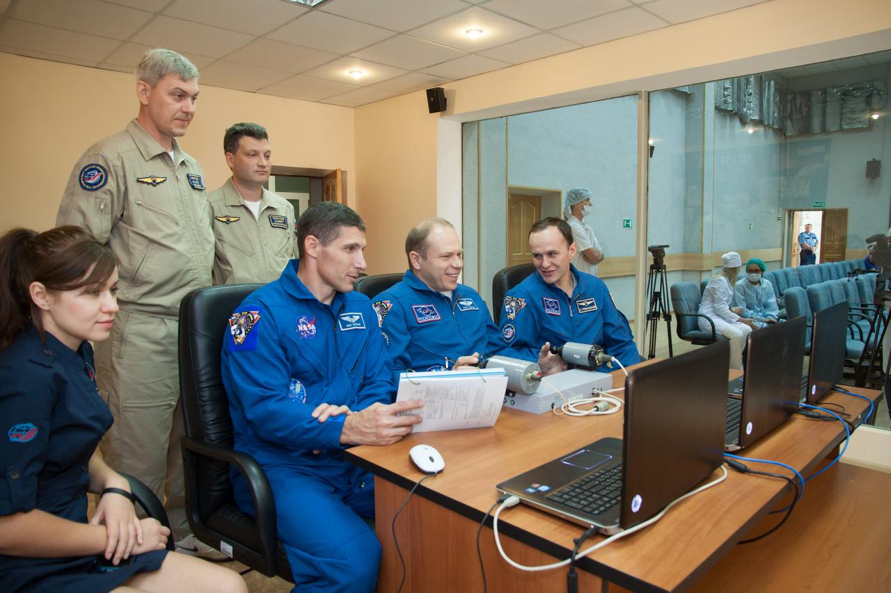 At their Cosmonaut Hotel crew quarters in Baikonur, Kazakhstan, Expedition 37/38 Flight Engineer Michael Hopkins of NASA (left), Soyuz Commander Oleg Kotov (center) and Flight Engineer Sergey Ryazanskiy come under the watchful eye of training instructors Sept. 18 as they practice rendezvous and docking techniques on a laptop computer simulator. Hopkins, Kotov and Ryazanskiy are set to launch Sept. 26, Kazakh time, from the Baikonur Cosmodrome on their Soyuz TMA-10M spacecraft for a five and a half month mission on the International Space Station.  NASA/Victor Zelentsov 