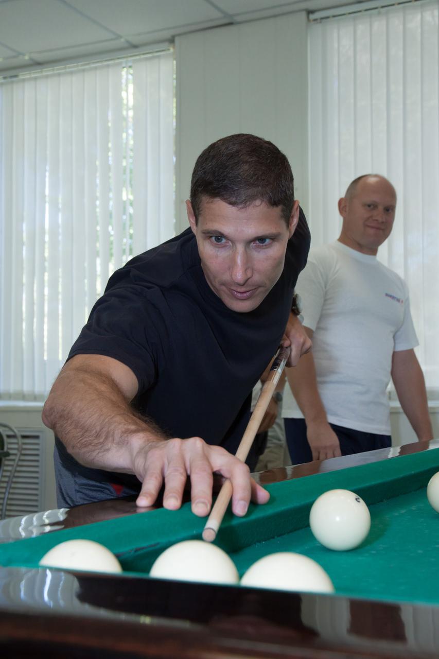 Under the watchful eye of backup crewmember Oleg Artemyev (rear), Expedition 37/38 Flight Engineer Michael Hopkins of NASA plays a game of billiards at the Cosmonaut Hotel crew quarters in Baikonur, Kazakhstan Sept. 18. Hopkins, Soyuz Commander Oleg Kotov and Flight Engineer Sergey Ryazanskiy are set to launch Sept. 26, Kazakh time, from the Baikonur Cosmodrome on their Soyuz TMA-10M spacecraft for a five and a half month mission on the International Space Station.  NASA/Victor Zelentsov 
