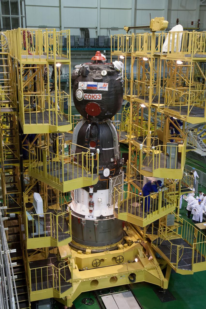 In the Integration Facility at the Baikonur Cosmodrome in Kazakhstan, the Soyuz TMA-10M spacecraft is prepared for encapsulation into the third stage of a Soyuz booster rocket Sept. 19. The Soyuz spacecraft will move to its launch pad Sept. 23 for final preparations for launch Sept. 26, Kazakh time, to carry Expedition 37/38 Flight Engineer Michael Hopkins of NASA, Soyuz Commander Oleg Kotov and Flight Engineer Sergey Ryazanskiy into orbit for the start of a five and a half month mission on the International Space Station.  NASA/Victor Zelentsov 