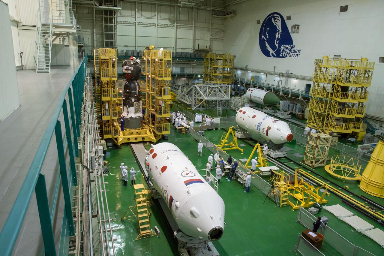 In the Integration Facility at the Baikonur Cosmodrome in Kazakhstan, the Soyuz TMA-10M spacecraft hovers behind the third stage of a Soyuz rocket Sept. 19 prior to its encapsulation into the booster. Standing in the midst of other Soyuz rocket components being prepared for future flights, the Soyuz spacecraft will move to its launch pad Sept. 23 for final preparations for launch Sept. 26, Kazakh time, to carry Expedition 37/38 Flight Engineer Michael Hopkins of NASA, Soyuz Commander Oleg Kotov and Flight Engineer Sergey Ryazanskiy into orbit for the start of a five and a half month mission on the International Space Station. NASA/Victor Zelentsov