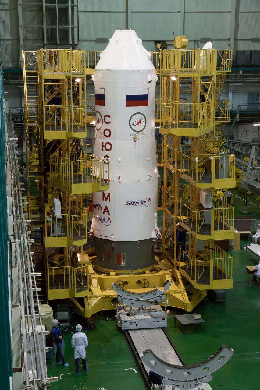 With the Soyuz TMA-10M spacecraft nestled inside, the third stage of a Soyuz booster rocket stands erect in the Integration Facility at the Baikonur Cosmodrome in Kazakhstan Sept. 19. The “encapsulation” process set the stage for the third stage of the Soyuz booster to be mated with two other rocket stages Sept. 22 in advance of the rocket’s rollout to the launch pad in Baikonur Sept. 23. Expedition 37/38 Flight Engineer Michael Hopkins of NASA, Soyuz Commander Oleg Kotov and Flight Engineer Sergey Ryazanskiy will launch on the Soyuz Sept. 26, Kazakh time, for the start of a five and a half month mission on the International Space Station.  NASA/Victor Zelentsov 